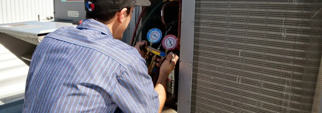 HVAC technician servicing a condenser unit in Tallmadge